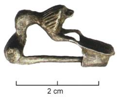 FIB-4586 - Fibule léontomorpheargentFibule à charnière, arc remplacé par le corps entier d'un lion posant les pattes antérieures (entre lesquelles peut apparaître une tête de bovidé, rivetée par dessous) sur une plaque rectangulaire ou légèrement trapézoïdale, cannelée.