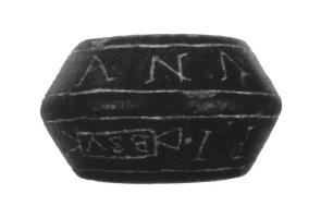 FUS-4004 - Fusaïole inscriteschiste bitumineuxFusaïole bitronconique, dont les deux faces obliques portent une inscription incisée, généralement entre deux filets.