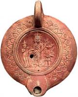 LMP-41942 - Lampe à bec rond : Isis, Harpocrate, Hermès-Anubisterre cuiteLampe à bec rond, anse verticale perforée ; bandeau orné de feuilles et motifs estampés ; sur le médaillon, Isis entourée d'Harpocrate et d'Hermès-Anubis.