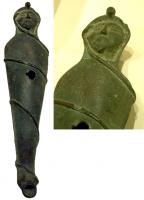 LMP-5075 - Lampe plastique : momiebronzeLampe figurative, représentant le corps d'un défunt entièrement entouré de bandelettes, à l'excepton de la tête; trou de remplissage au centre du corps, trou de mèche sur les pieds; sur le corps, fréquentes inscriptions magiques en caractères grecs. Le style égyptien peut être plus ou moins marqué, ou totalement absent selon les objets.