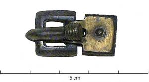 PLB-5641 - Plaque-boucle articuléeargent doréPlaque carrée, à rivet central, articulée par deux replis formant charnons sur une boucle également carrée, à décor réticulé sur les côtés.