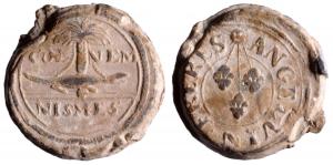SCL-9096 - Plomb de fabrique : Nîmes, Angelvin FrèresplombSceau à double face : d'un côté, armes de la ville de Nîmes (crocodile enchaîné à un palmier), de part et d'autre COL / NEM; de l'autre, inscription autour de 3 fleur de lis suyspendues à un astre ; ANGELVIN FRERES.
