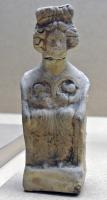 STE-4315 - Statuette : déesse mèreterre cuiteDéesse-mère assise dans un fauteuil en osier, accompagnée d'un ou plusieurs enfants (allaités ou non).