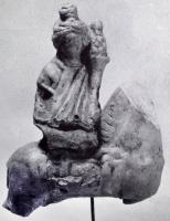 STE-4494 - Statuette : Eponaterre cuiteFigurine représentant la déesse assise en amazone sur un cheval, qui peut être bridé et/ou sellé ; elle peut être dépourvue d'attributs, ou tenir une corbeille de fruits sur ses genoux.