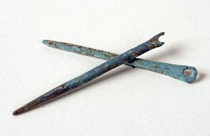 AIG-3004 - Aiguille à coudrebronzeAiguille constituée d'une tige filiforme généralement peu allongée, de section ronde pouvant être aplatie vers la tête, où a été individualisé un chas circulaire; sommet plat ou arrondi.