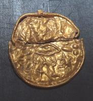 AML-4001 - AmuletteorAmulette en feuille d'or estampée, de forme ovale pourvue au revers d'un anneau plat et mouluré ; au centre, un œil droit encadré de traits courbes (cils ?), au-dessus un foudre et, dans le sens des aiguilles d'une montre : lézard ou salamandre tête en bas, phallus ailé, scorpion, chien, lion, oiseau au long cou et ailes déployées, serpent, étoile ; bordure de perles.