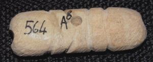 AML-4056 - AmuletteosAmulette en forme de bâtonnet trapu, percé au centre, et façonné pour figurer sans doute deux phallus stylisés.