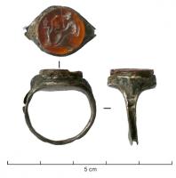 BAG-4219 - Bague à intailleargentTPQ : 150 - TAQ : 300Bague à jonc lisse, étroit, s'élargissant brusquement pour former un chaton constitué d'une intaille sertie dans l'épaisseur du jonc. 