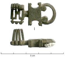 CLE-4092 - Clé à translationbronzeClé entièrement coulée, à tige courte prolongée par une large boucle à crosses, posée sur un blocs rectangulaire à moulure transversale, ou encoches latérales; le panneton rectangulaire se développe sur deux plans perpendiculaires, très ajouré pour le premier et en dents parallèlespour le second. 