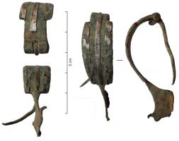 FIB-41086 - Fibule de type AlésiabronzeFibule à arc plat, de forme triangulaire ou ogivale, charnière repliée vers l'intérieur et pied redressé, généralement percé d'un ornement transversal (bâtonnet, perles...); l'arc triangulaire est ici remplacé par une plaque rectangulaire, ornée de deux bandes de motifs en S, incrustés d'argent, de part et d'autre d'une bande médiane lisse, également incrustée d'argent.