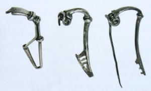 FIB-41410 - Geschweifte FibelargentFibule à arc fortement coudé à la tête ; après une nodosité, le profil est au contraire très tendu voire cambré ; porte-ardillon triangulaire ajouré ou fenestré.