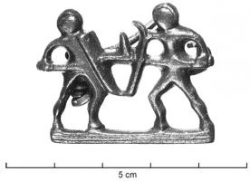 FIB-41676 - Fibule anthropomorphe : gladiateursbronzeFibule figurative représentant en relief plat ajouré, sur une ligne de sol, deux gladiateurs casqués combattant, armés de glaives et de boucliers dont l'enchevêtrement dessine les lettres V(tere) F(elix). Au revers, articulation à charnière entre deux plaquettes.