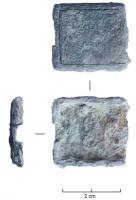 FRT-8004 - Mordant : boîtier composite à crochetcuivreBoîtier quadrangulaire, carré ou légèrement trapézoïdal, décoré de lignes gravées sur une face, dont l'extrémité distale ménage une encoche pour l'accueil d'un accessoire de type crochet. L'extrémité proximale est fermée et fixée grâce à des rivets.