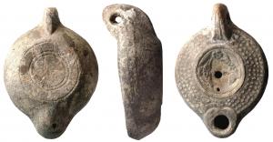 LMP-41865 - Lampe à bec cordiforme : globules, poissonsterre cuiteAnse forée à trois sillons. Bandeau de profil Loeschcke VIIIb orné de quatre rangs de globules. Disque décoré latéralement de deux poissons tête-bêche, d’une fleur à cinq pétales côté anse, d’un trou d’évent côté bec. Base annulaire avec un cercle contre le bord interne de l’anneau.