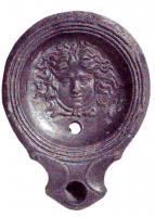 LMP-4863 - Lampe Loeschcke I : Tête de Méduseterre cuiteLampe ronde sans anse, à large bec en enclume encadré de volutes. Médaillon décoré d'une tête de Méduse.