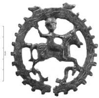 MRS-5003 - Applique latérale de morsbronzeApplique circulaire au pourtour dentelé, avec une bélière rectangulaire au sommet pour la fixation des sangles. Le décor ajouré figure un cavalier sur son cheval.