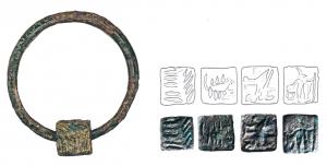 SIG-4038 - Matrice de sceau cubique ou polyédriquebronzeMatrice cubique (parfois aux angles abattus), perforée verticalement et dont les quatre faces verticales portent des motifs figurés ou des inscriptions. L'objet peut être monté sur un anneau.