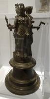 STE-4479 - Statuette : triple HécatebronzeDivinité lunaire, Hécate peut être associée à Artemis et Séléné  pour personnaliser la triade ; chaque figuration féminine brandit des objets symboliques / ésotériques : poignard, torche, clé...