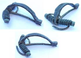 FIB-4531 - Fibule en arbalètebronzeTPQ : 300 - TAQ : 425Fibule à arc facetté, de largeur constante, pied très court ; tête percée pour ressort sur axe, de 6 à 12 spires et corde interne.
