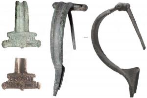 FIB-4690 - Fibule de type Aucissa : LOVST ?bronzeFibule d'Aucissa, à arc creusé d'une cannelure médiane, charnière  repliée vers l'intérieur, avec deux boutons latéraux, rapportés sur l'axe. Au dessus, une estampille parallèle à la charnière : LOVST ou LOXST.