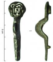 FIB-5082 - Fibule à tête scutiformebronzeFibule à pied et arc étroits, dans le prolongement l'un de l'autre ; à la tête, plaque scutiforme à décor d'entrelacs incisés.