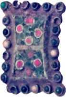 FIB-6051 - Fibule rectangulaire émailléebronzeFibule plate, rectangulaire à bords légèrement concaves, bord festonné pour suivre la bordure de perles rapportées ; au centre, motifs émaillés.