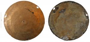 IND-4098 - Objet à identifierbronze, plombGrand disque en tôle, légèrement bombé et orné sur cette face de cercles concentriques; le bord est percé de trois ouvertures quadrangulaires dont l'une a conservé, au revers, une masse de plomb coulée sur l'orifice. Repli grossièrement rabattu sur la face concave.