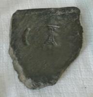 MOU-9006 - MoulepierreMoule constitué d'une plaque de schiste ou d'ardoise, avec des empreintes juxtaposées en creux, mais sans canal de coulée ni trou de calage.