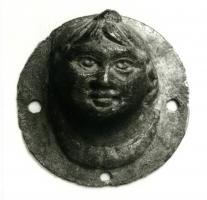 PHA-4002 - Phalère : tête d'enfantbronzeMédaillon creux en bronze, représentant un buste tête d'enfant (corymbe) sur une lunule, ou parfois le seul visage ; collerette plate, percée de 4 trous de fixation.