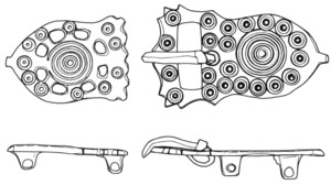 PLB-5185 - Plaque-boucle rigidebronzeTPQ : 575 - TAQ : 640Plaque-boucle rigide, en forme d'amphore, ornée de motifs circulaires et oculés; contre-plaque de même forme.