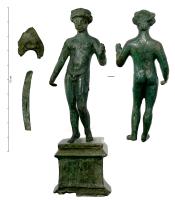 STE-4546 - Statuette : Apollon ou AdonisbronzePersonnage masculin, jeune et nu, en léger déhanché sur la jambe droite, la tête ceinte d'une couronne ; coiffure de type féminin avec un chignon à l'arrière du crâne. Attributs incomplets et détachés.