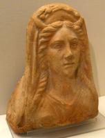 ANT-4018 - Antéfixe : Buste d'Artemis-Selene / Lunaterre cuiteAntéfixe de style classique, représentant un buste féminin aux traits réguliers, bien détaillés, aux longs cheveux tombant sur les épaules, et surmonté d'un croissant qui permet de reconnaître Artemis-Selene, ou Luna. Au-dessus, diadème.