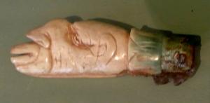 CNF-4049 - Canif : tête de grotesquefer, osTPQ : 1 - TAQ : 400Canif dont le manche sculpté représente une tête grotesque, lippue, au nez busqué, émergeant d'un fleuron; lame en fer et virole de bronze.