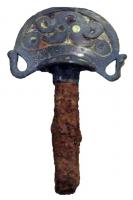 CVC-3003 - Clavette de charfer, bronzeClavette en bronze, coulée sur une forte tige en fer, de section quadrangulaire; la tête hémisphérique est accostée de crosses, et creusée de motifs éméillés de style celtique; du côté extérieur, elle est aussi prolongée par une butée qui permet de bloquer la clavette en position.