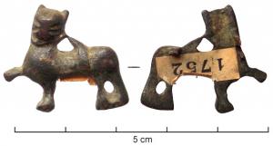 FIB-6122 - Fibule zoomorphe : lionbronzeFibule en forme de lion ailé, ou chimère, en position héraldique, la patte antérieure droite relevée; les deux pattes arrière sont reliées par une barre; l'aile est réduite à un triangle effilé reliant le dos à la nuque de l'animal; dorure.