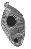LMP-41496 - Lampe pantoufle byzantine terre cuiteLampe allongée à bec incorporé, épaule décorée de traits rayonnants en relief, anse plastique en forme de tête ovine. Base ovale ornée de demi-volutes en relief.